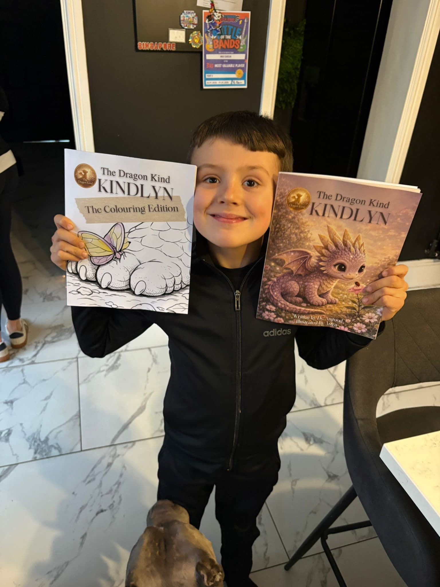 Happy child holding two Kindlyn books